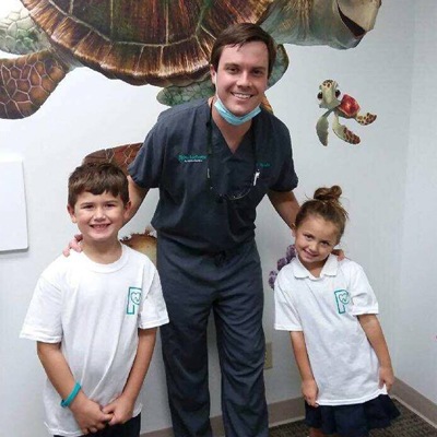Dr. posing with two young patients.