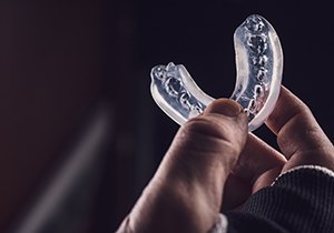 a person holding a transparent mouthguard