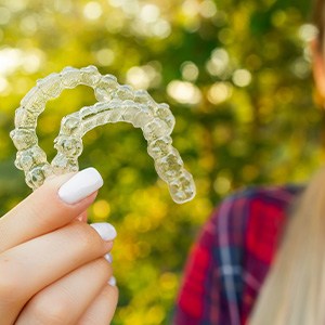 Patient in West Mobile smiling with their Invisalign aligners