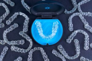 Bird's eye view of Invisalign case surrounded by multiple aligners